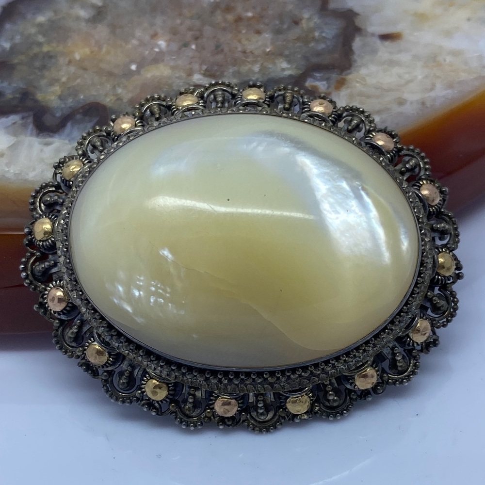 Antique mother-of-pearl brooch set in Sterling silver with brass accents